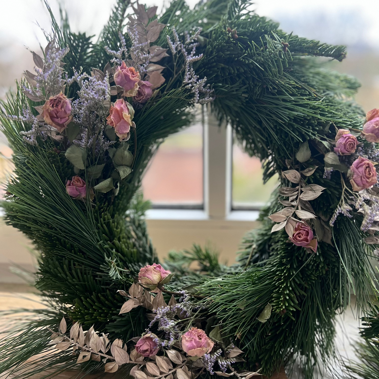 Selbst gebundener Adventskranz aus frischem Tannengrün mit handgetauchten Dip-Dye-Kerzen in sanften Farbverläufen, arrangiert unter dem Motto „Adventskranz binden & Dip Dye Candles – Lost in Perfection".