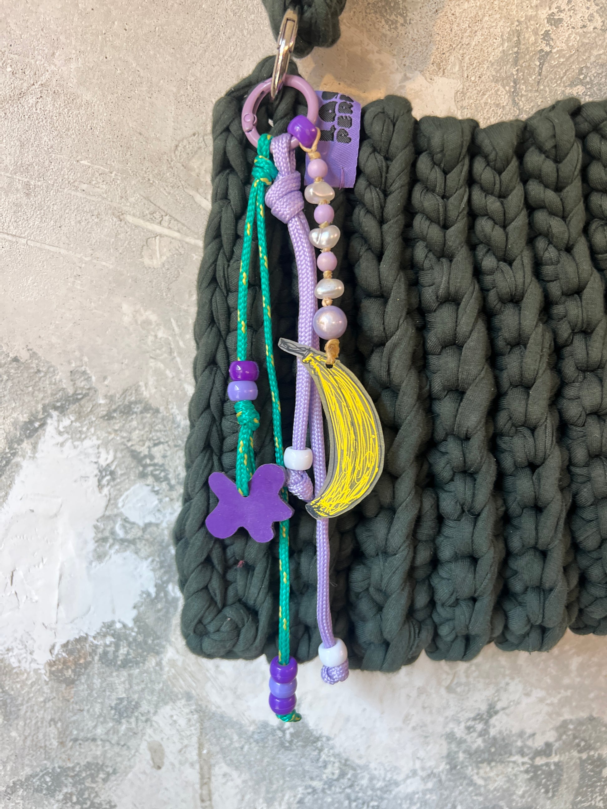 DIY workshop in München. Man sieht eine Tasche mit einem Charm mir Bananen Anhänger Perlen und Paracord.