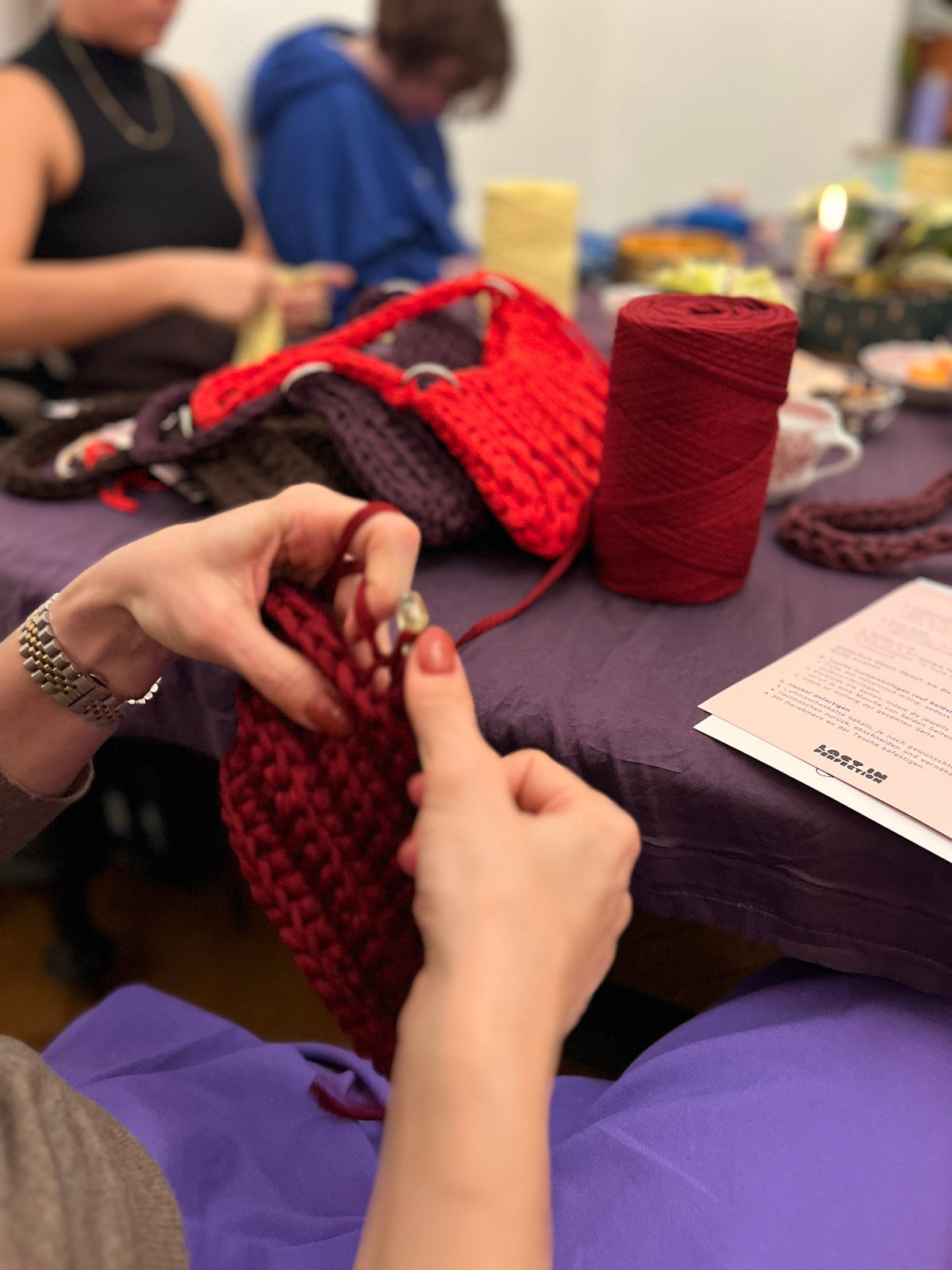 Workshopsituation mit Jerseywolle und Teilnehmerinnen am Tisch.