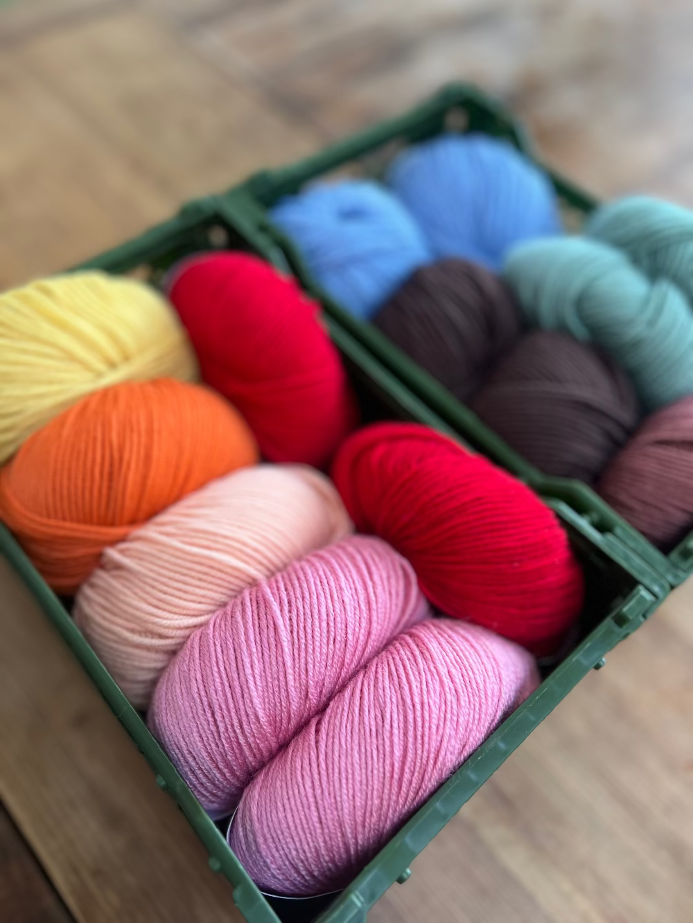 Bunte Merino Wolle auf dem Tisch in Boxen in München für den nächsten Workshop.