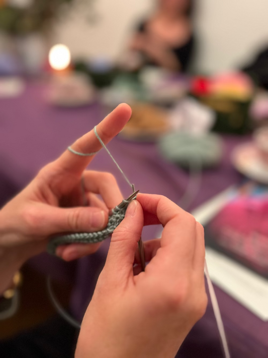 Hände halten Stricknadeln und feine wolle beim Halstuch Strickkurs in München.