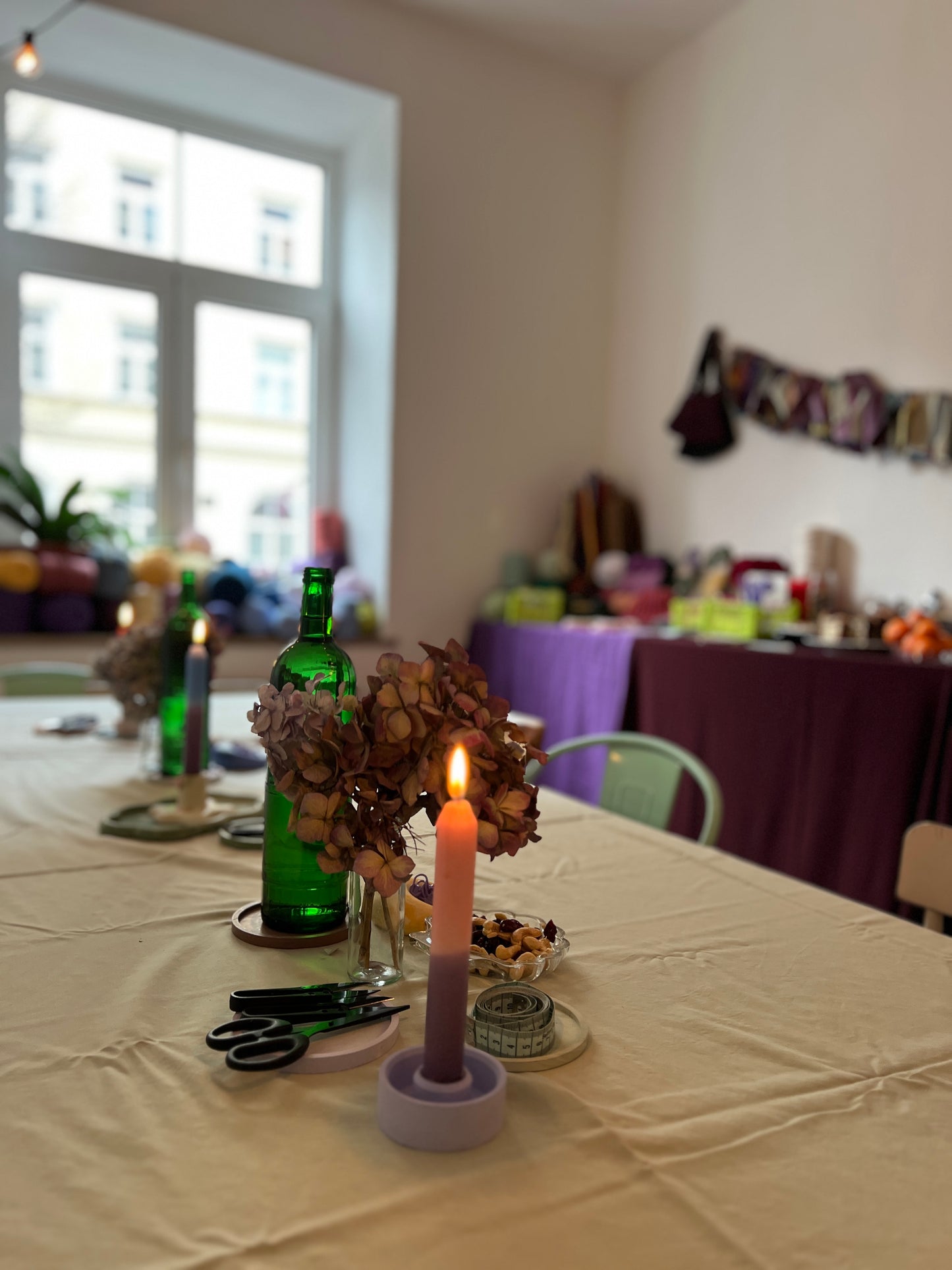 Tisch für den Stricktreff vorbereitet mit Kuchen, Wolle, Stricknadeln, Maschenmarkierer, Kaffee und Snacks.