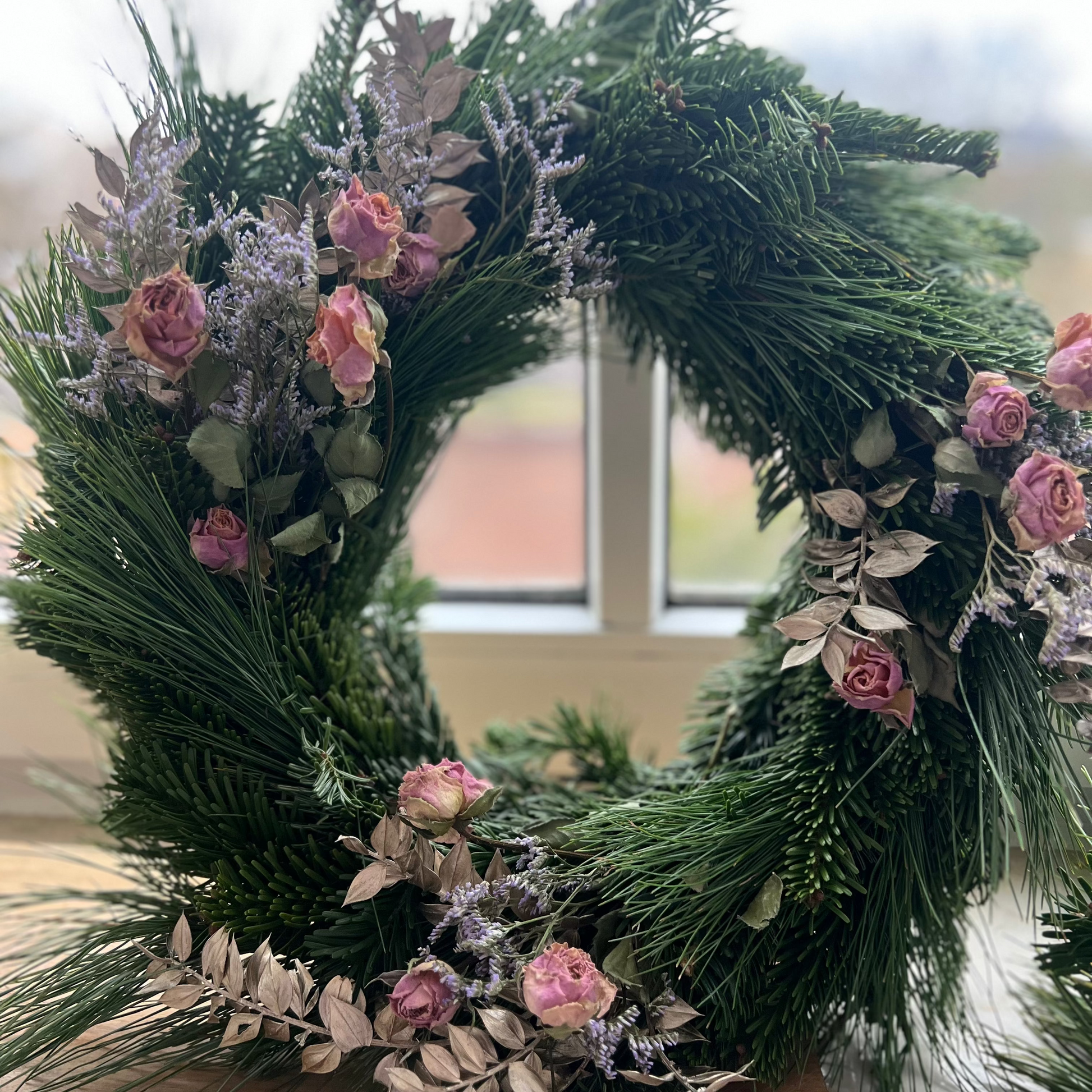 Selbst gebundener Adventskranz aus frischem Tannengrün mit handgetauchten Dip-Dye-Kerzen in sanften Farbverläufen, arrangiert unter dem Motto „Adventskranz binden & Dip Dye Candles – Lost in Perfection".