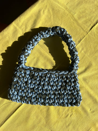 Tasche selbst gehäkelt auf Tisch.