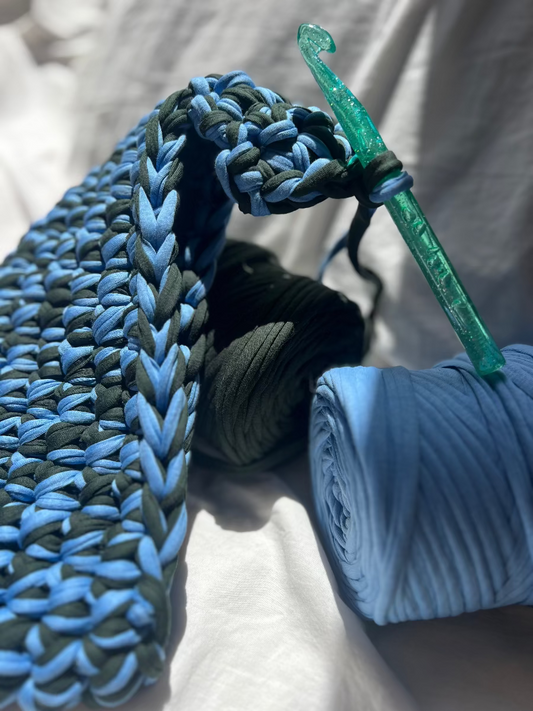 Blau gruenes recycling Garn aus dem ein Taschenhaenkel gehäkelt wird bei einem Event in München
