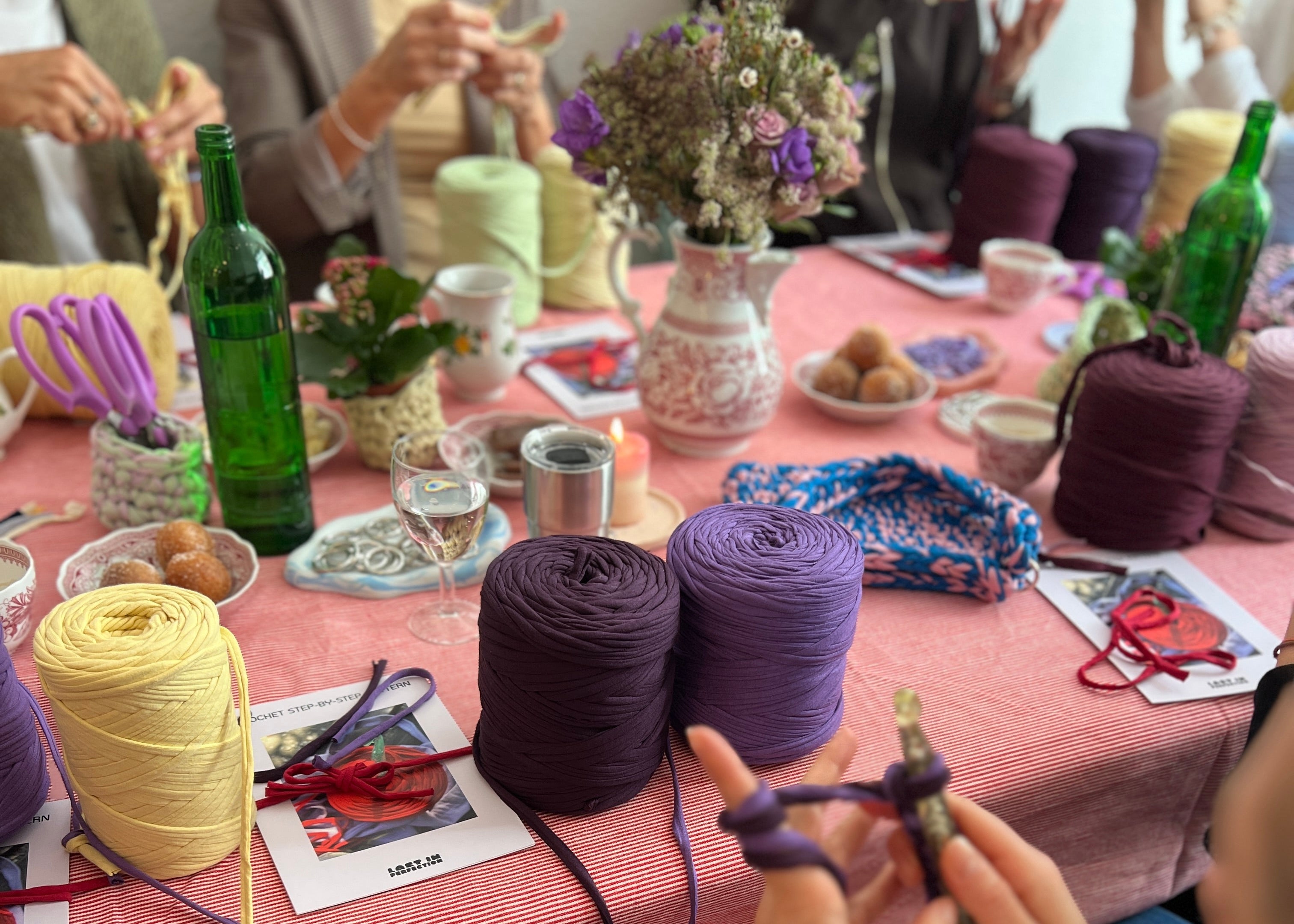 Frauen sitzen zusammen und haekeln Taschen beim Workshop.