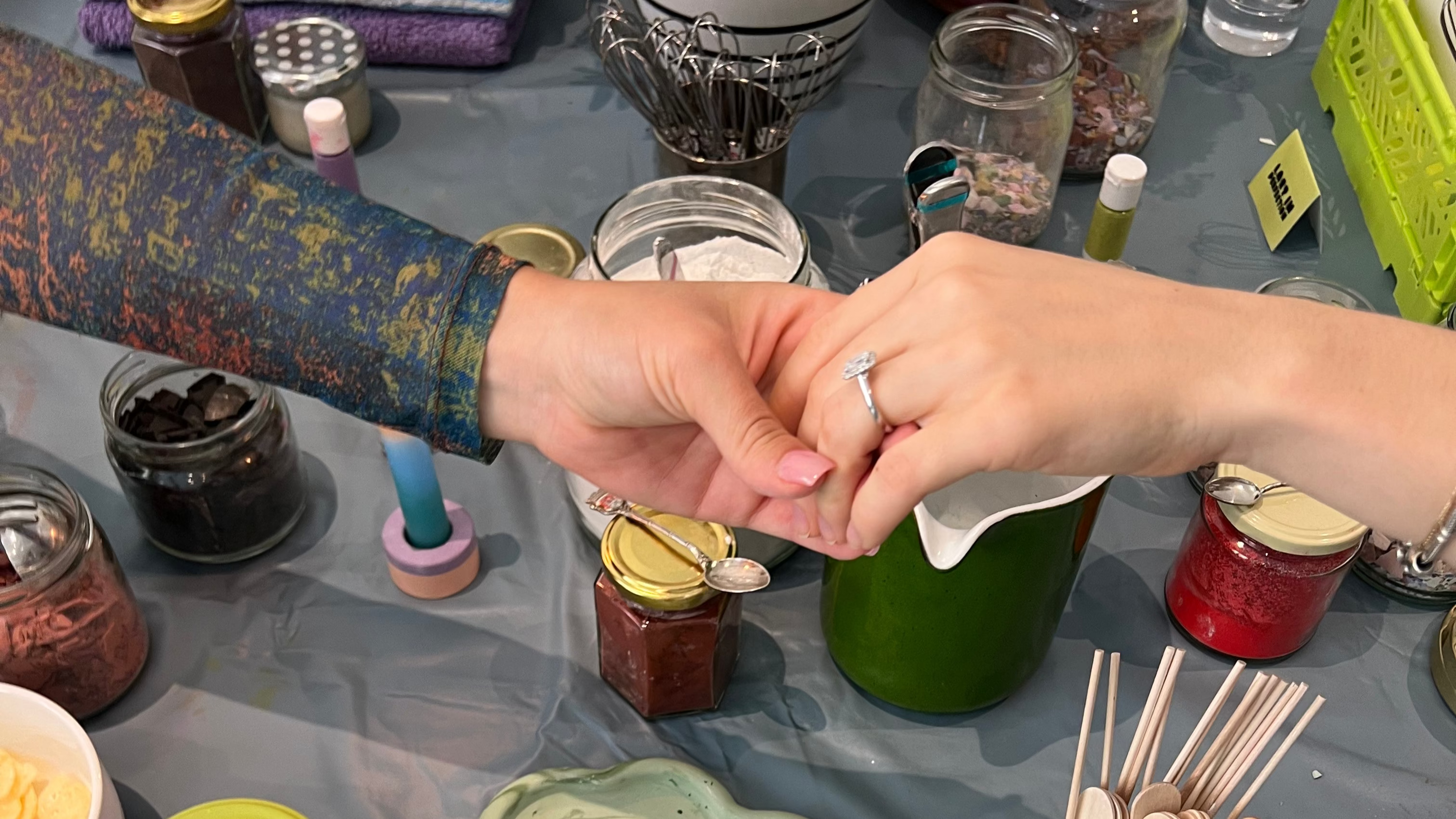 DIY-Workshop beim Raysin gießen Frauen zeigen sich den Verlobungsring